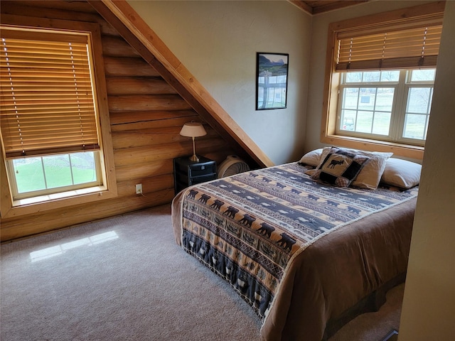 bedroom featuring multiple windows, rustic walls, and carpet floors