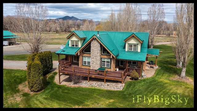 rear view of property featuring a lawn, a mountain view, and a porch