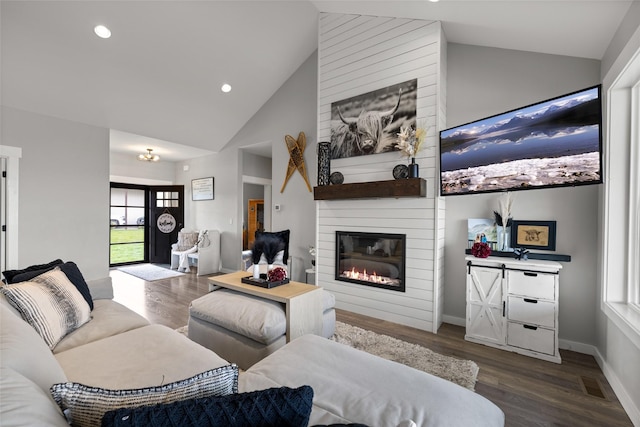 living room featuring hardwood / wood-style flooring, a fireplace, and high vaulted ceiling