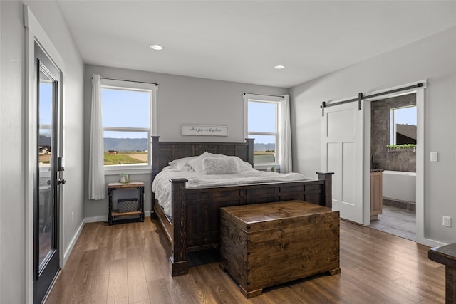 bedroom with dark wood-type flooring and a barn door