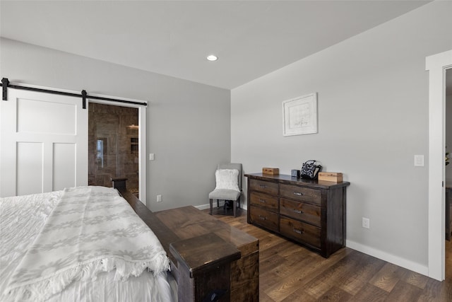 bedroom with dark hardwood / wood-style flooring and a barn door