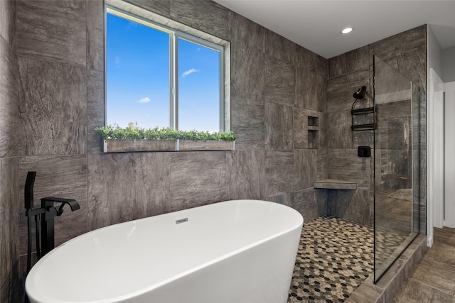 bathroom featuring independent shower and bath and tile walls