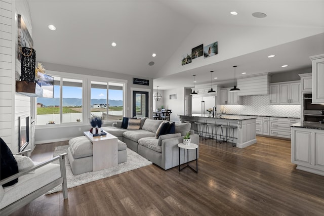 living room with a mountain view, sink, high vaulted ceiling, and dark hardwood / wood-style floors