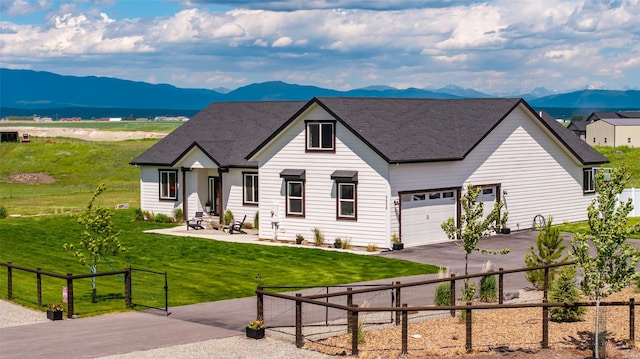 view of front facade with a garage, a mountain view, and a front yard