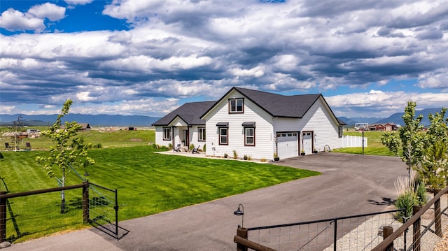 view of front facade with a mountain view, a garage, and a front lawn