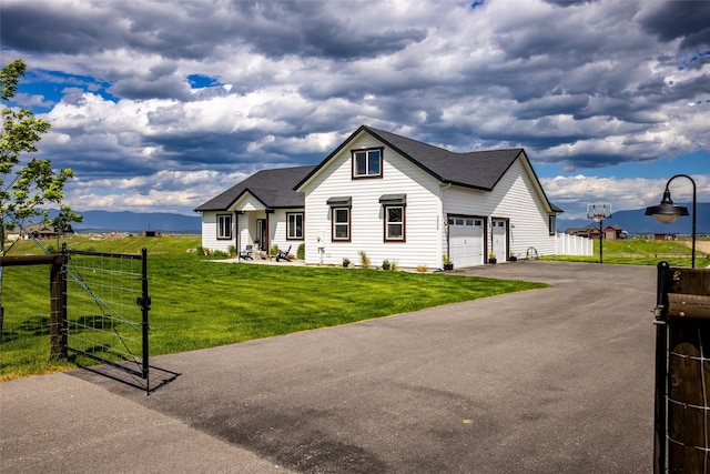 view of front of house featuring a garage, a mountain view, and a front lawn