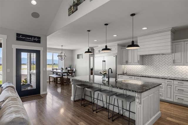 kitchen featuring a large island, a breakfast bar, and built in refrigerator