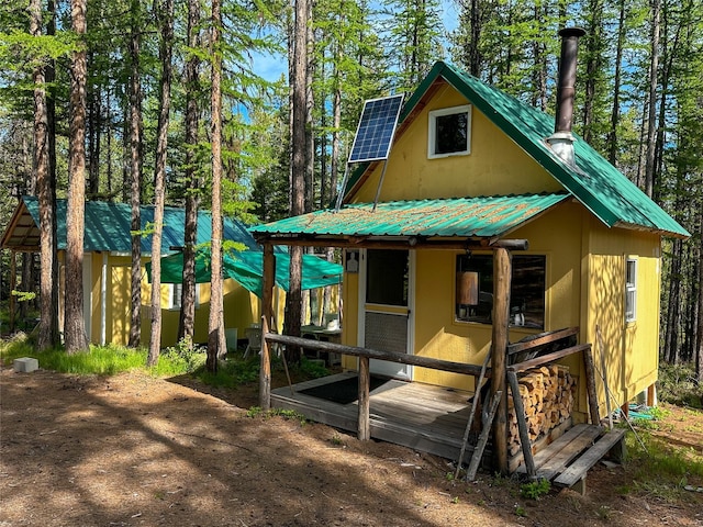 view of front of property with metal roof and solar panels