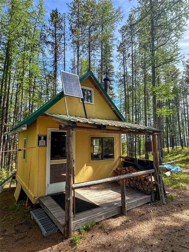 rear view of property featuring a deck and metal roof