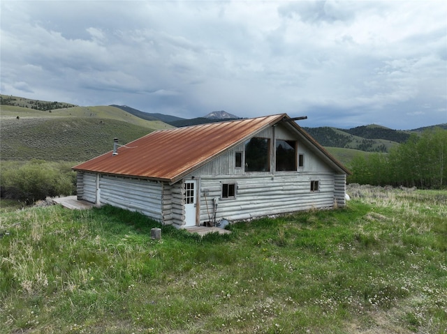 view of home's exterior with a mountain view and an outbuilding