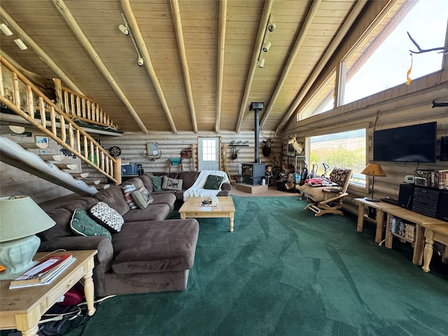 carpeted living room featuring a healthy amount of sunlight, rail lighting, a wood stove, and wood ceiling