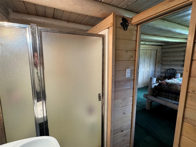 bathroom featuring beam ceiling, wooden ceiling, rustic walls, and walk in shower