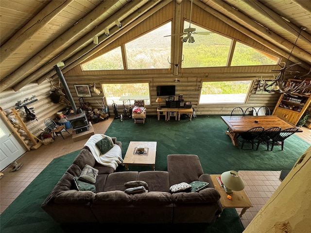 living room featuring wood ceiling, beam ceiling, rustic walls, and a wood stove