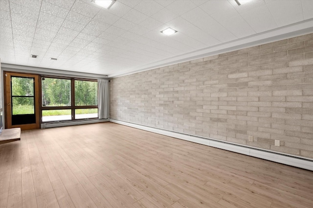 unfurnished living room featuring a baseboard radiator, brick wall, and light wood-style flooring