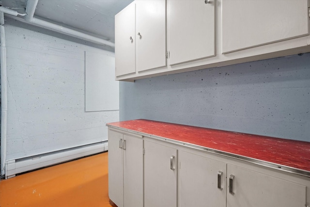 interior space with white cabinetry and a baseboard heating unit