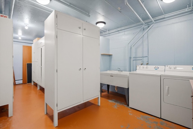 laundry room featuring baseboard heating, laundry area, a sink, and washing machine and clothes dryer