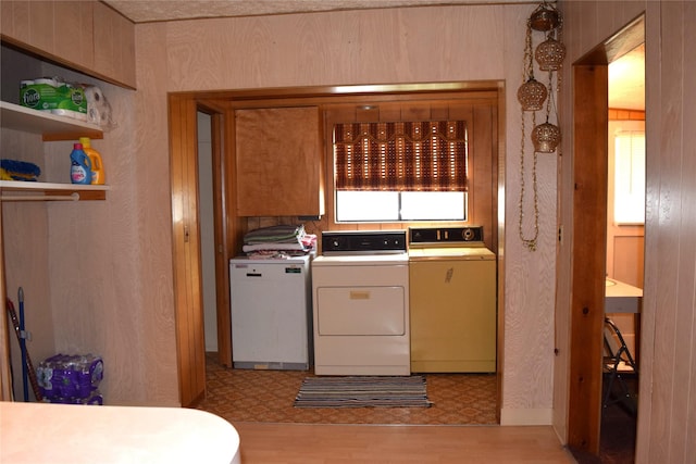 laundry area featuring separate washer and dryer and light hardwood / wood-style floors