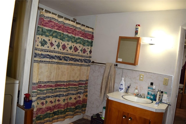 bathroom with a shower with curtain, vanity, and washer / clothes dryer