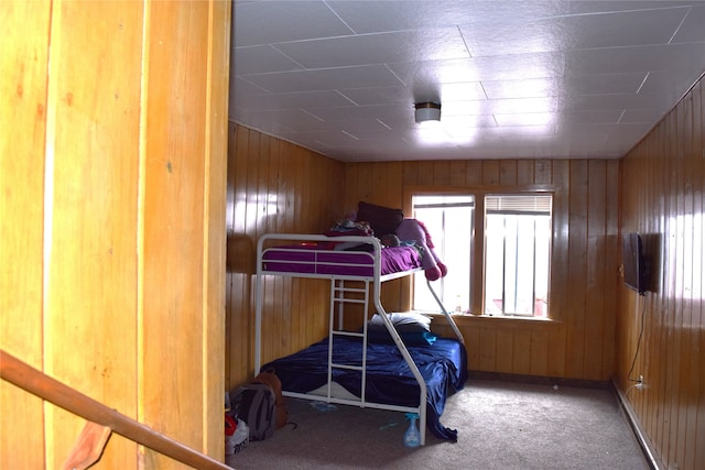 carpeted bedroom with wooden walls