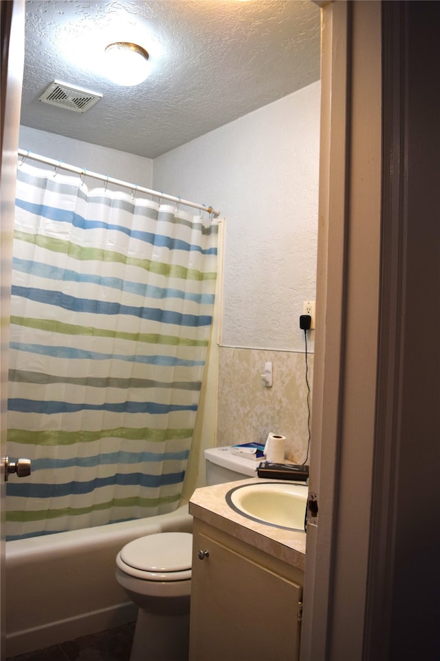 bathroom with vanity, toilet, a textured ceiling, shower / bathtub combination with curtain, and visible vents