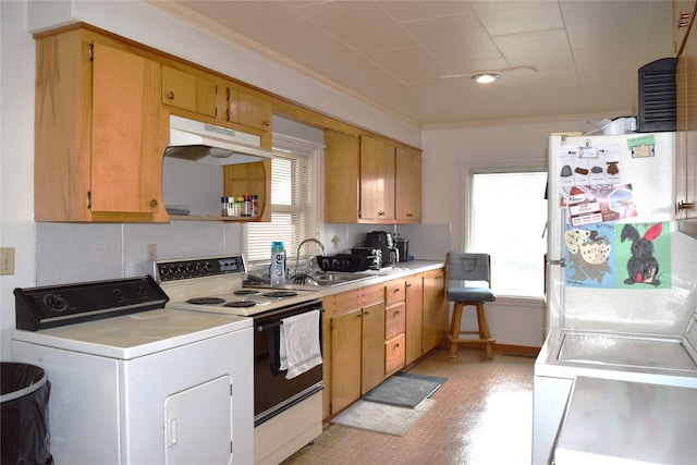 kitchen featuring light countertops, electric stove, freestanding refrigerator, washer / clothes dryer, and under cabinet range hood