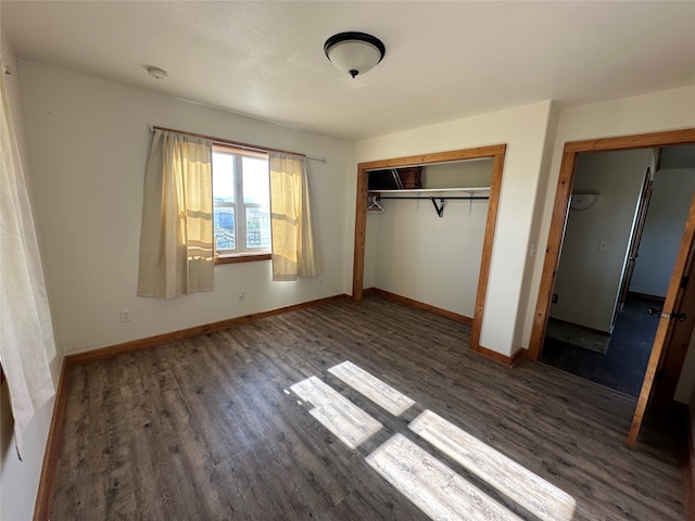 unfurnished bedroom featuring a closet and dark hardwood / wood-style flooring