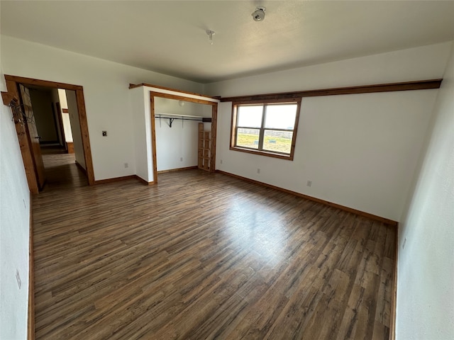 unfurnished bedroom featuring a closet and dark hardwood / wood-style floors