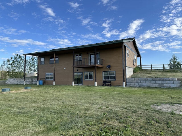 rear view of property with a yard and a balcony