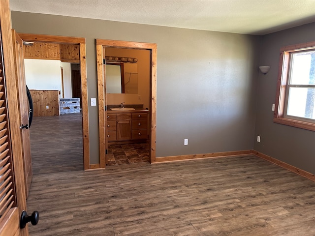 unfurnished room with dark hardwood / wood-style flooring, a textured ceiling, and sink