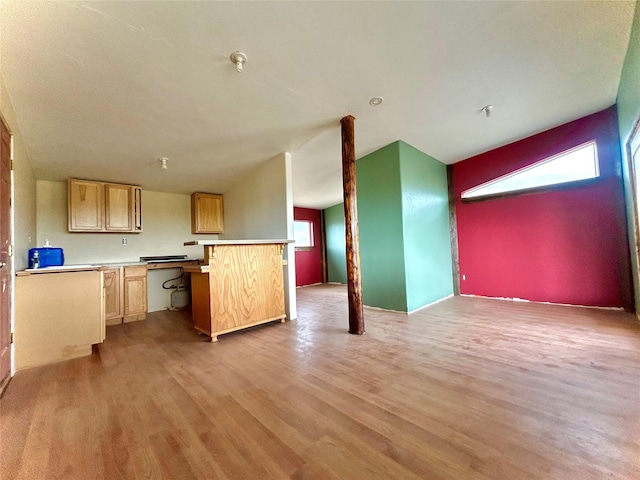 kitchen featuring light brown cabinets, light wood-type flooring, and kitchen peninsula