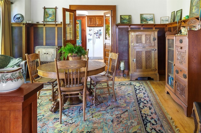 dining area with light wood-type flooring and an AC wall unit