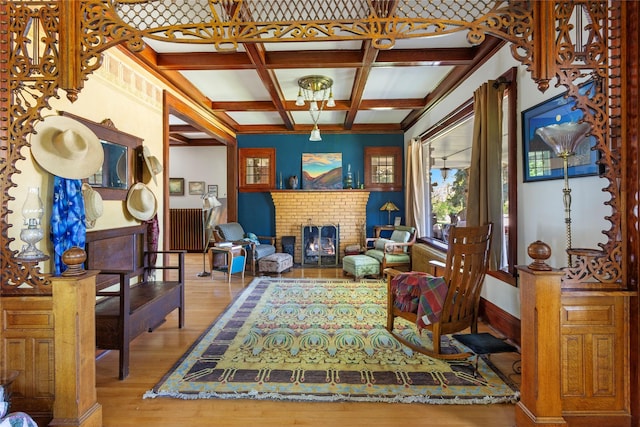 living area featuring a fireplace, hardwood / wood-style floors, beamed ceiling, and coffered ceiling