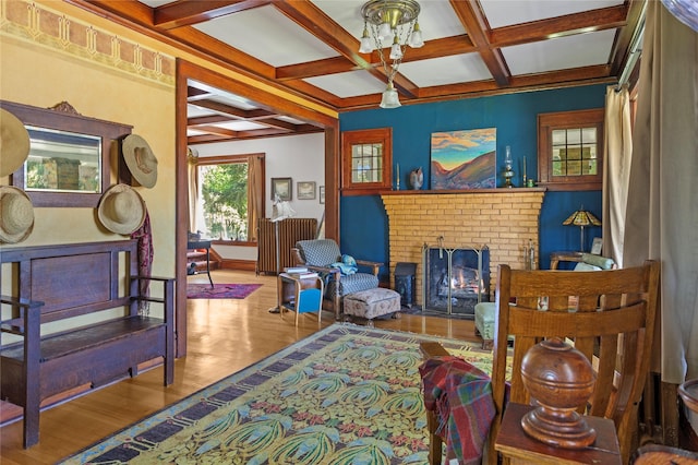 living area with a fireplace, hardwood / wood-style floors, coffered ceiling, and beam ceiling