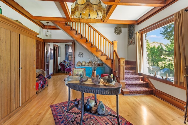 foyer with beam ceiling, light wood-type flooring, and coffered ceiling