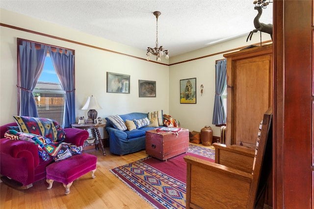 living room featuring hardwood / wood-style floors, a textured ceiling, and a notable chandelier