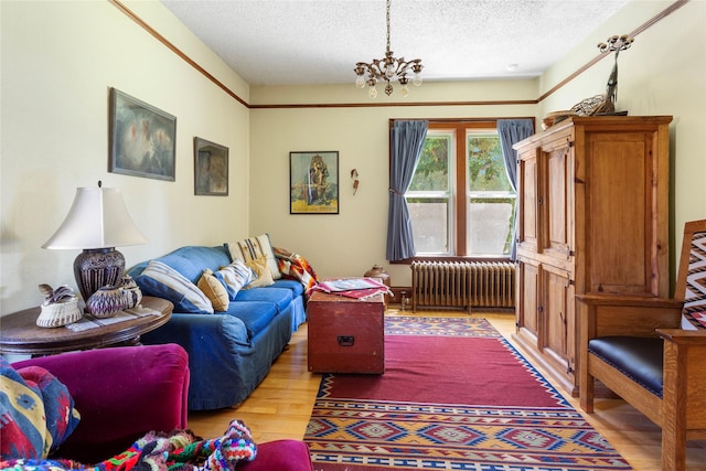 living room with radiator heating unit, a textured ceiling, light hardwood / wood-style floors, and a notable chandelier