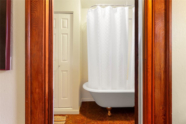 bathroom with tile patterned floors and a tub to relax in