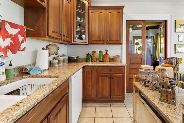 kitchen with light stone countertops, dishwasher, and light tile patterned floors