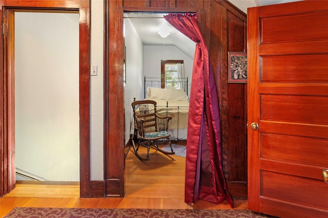 hallway featuring wood-type flooring and lofted ceiling