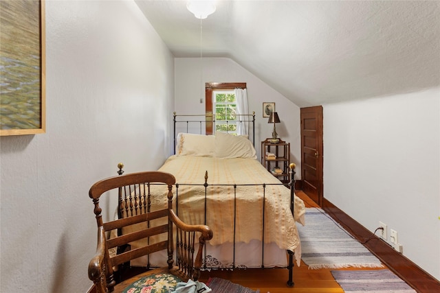 bedroom featuring wood-type flooring and vaulted ceiling