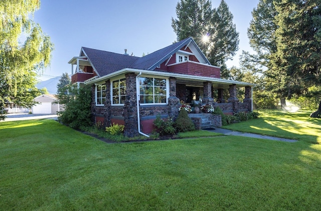 view of front of home with an outbuilding, a front lawn, a porch, and a garage