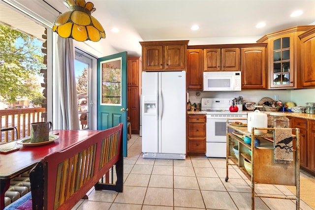 kitchen with light stone countertops, white appliances, and light tile patterned floors