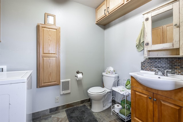 3851 Reed Butte Rd, Stevensville, MT 59870 - bathroom with washer / clothes dryer, toilet, vanity, heating unit, and backsplash