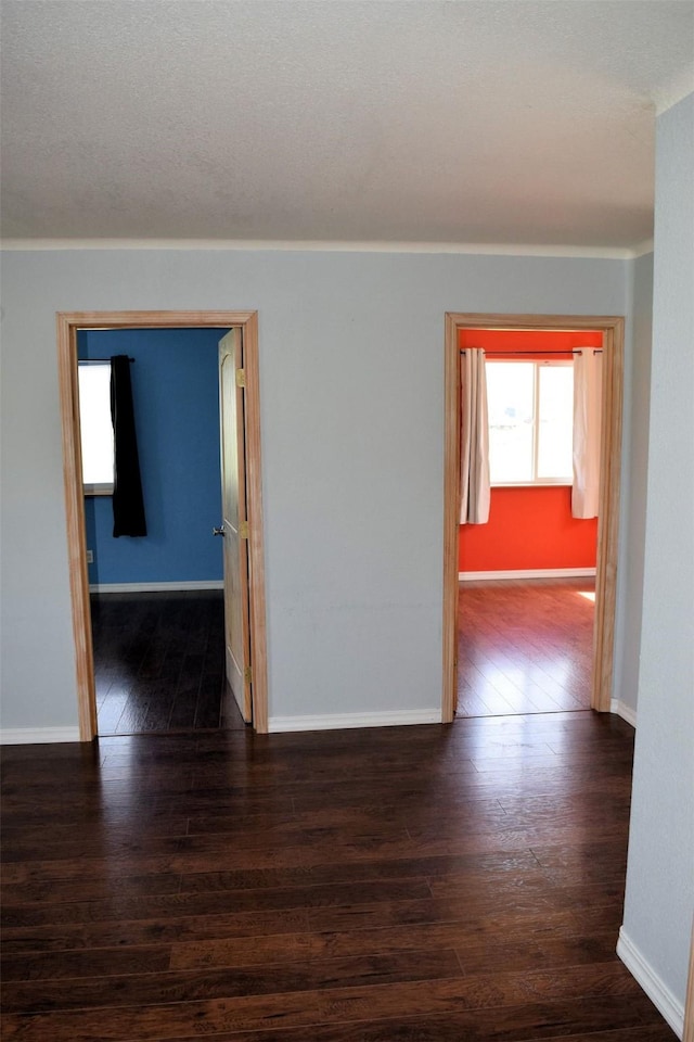 unfurnished room with dark hardwood / wood-style flooring and crown molding