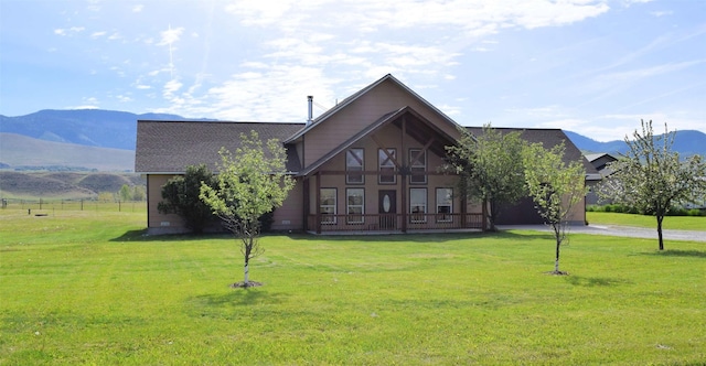 view of front of home with a mountain view and a front lawn