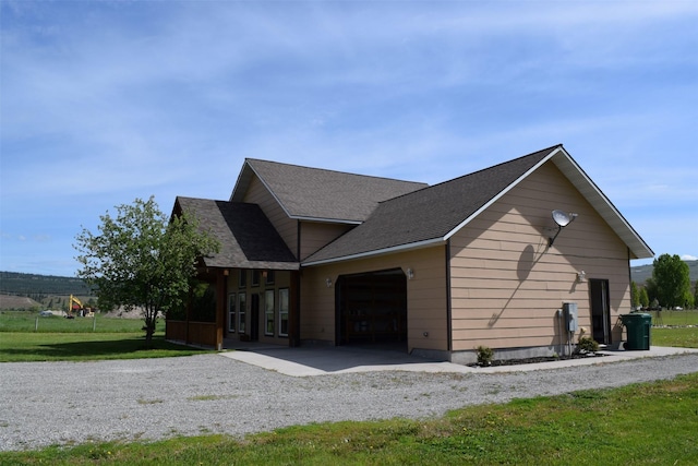 view of side of property featuring a garage and a yard