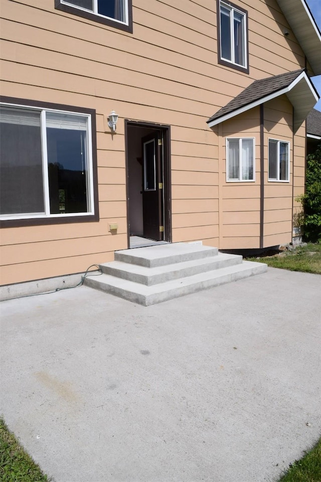 view of exterior entry with a patio area