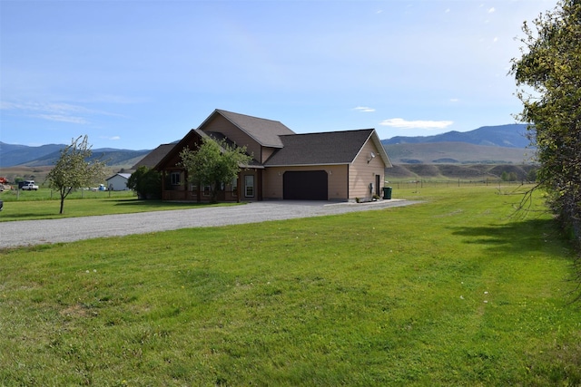 exterior space with a mountain view, a front yard, and a garage