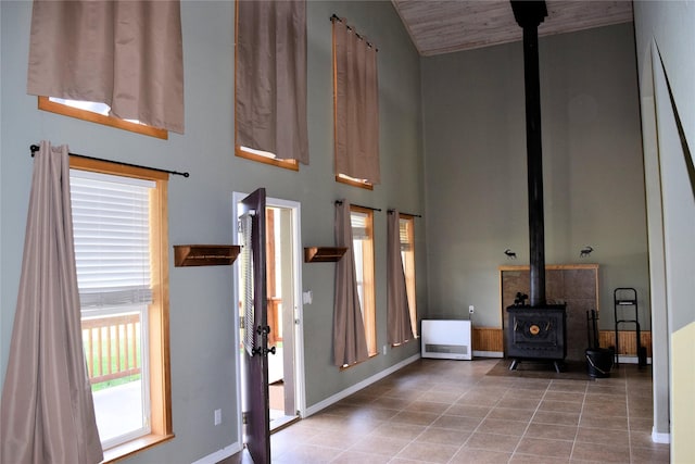 tiled foyer with a wood stove and vaulted ceiling