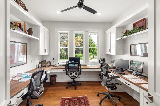 office area with ceiling fan, built in desk, and light hardwood / wood-style floors